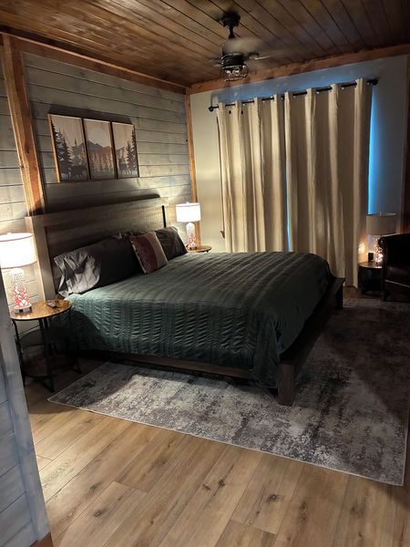 King bed with bedding, long curtains, and a wood-plank ceiling