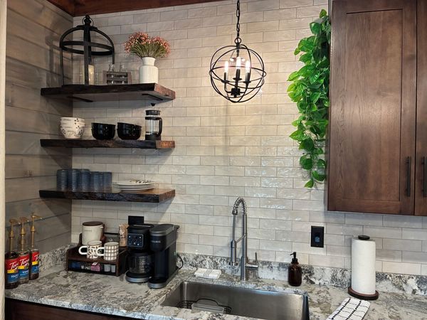 Kitchen sink with a subway-tile backsplash, open wood shelving, and a coffee station