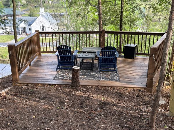 Overlook deck with two Adirondack chairs and a fire table, seen from the path