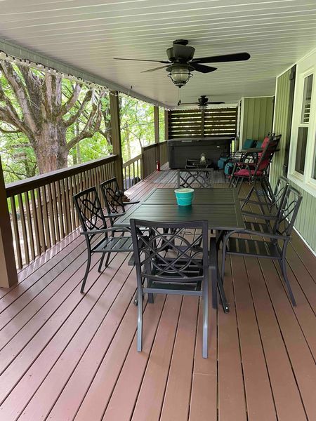 Outdoor dining table and chairs on the covered deck under a ceiling fan