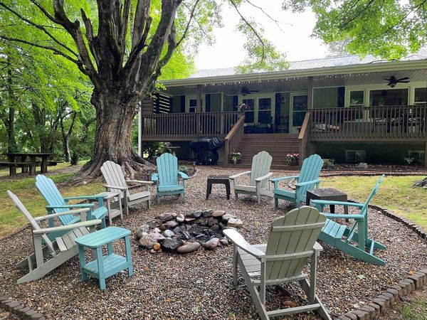 Fire pit circle with Adirondack chairs, with the Farmhouse back deck behind