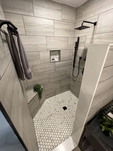 Walk-in shower with plank tile, a hexagon-tile floor, a wall niche, and a rain shower head