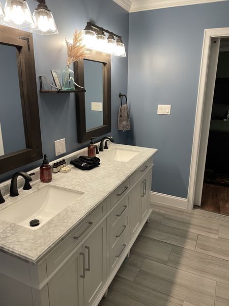 Master bath double vanity with a marble-look top and faucets, looking toward the bedroom door