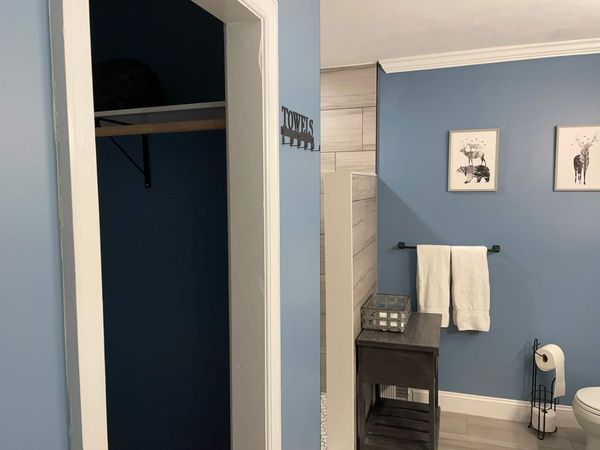 Master bedroom closet with a hanging rod and shelf, next to the master bathroom