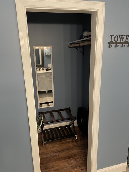 Master closet with a hanging rod, a luggage rack, and a full-length mirror