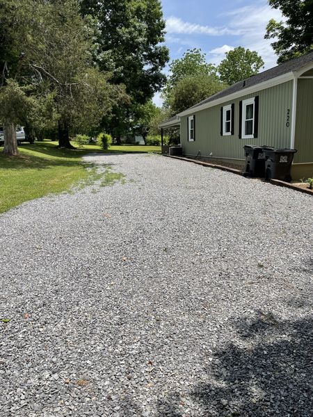 Gravel driveway running along the side of the Farmhouse