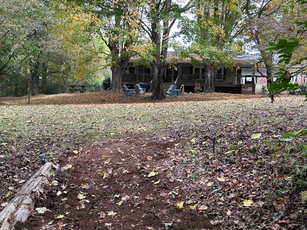 Leaf-covered path leading back from the river toward the Farmhouse and its fire pit